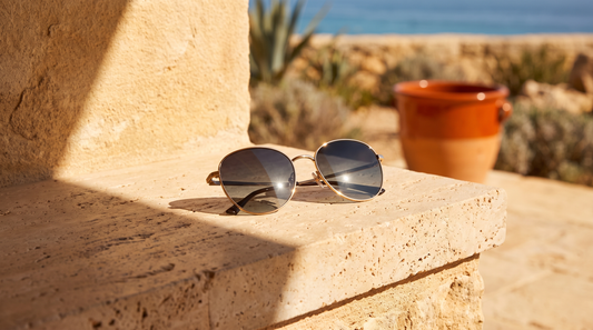 Lunettes de soleil elegantes posees sur une pierre de travertin en pleine lumiere marocaine